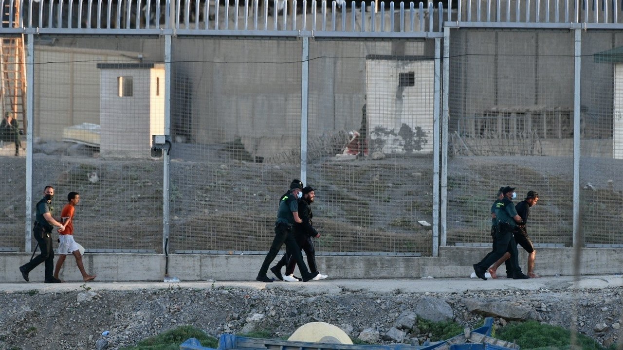 Agentes de la Guardia Civil, junto a extranjeros interceptados en la valla de Ceuta (Foto: Antonio Sempere / Europa Press)