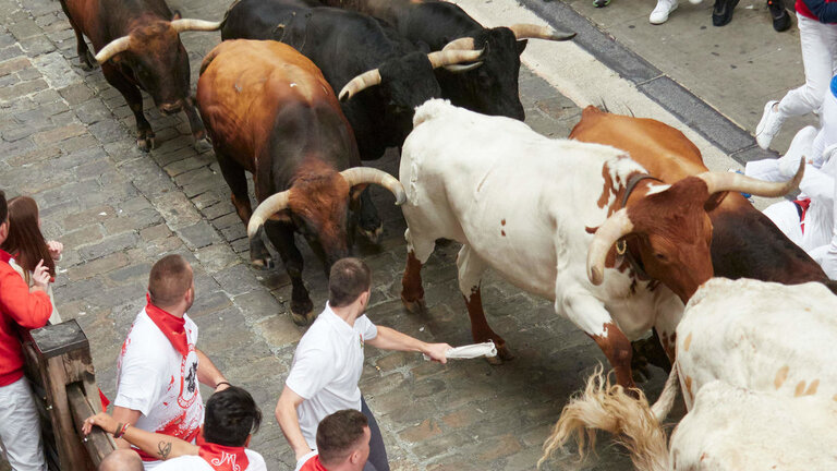 Multitud de personas corren durante el primer encierro de las Fiestas de San Ferm&iacute;n 2023. 