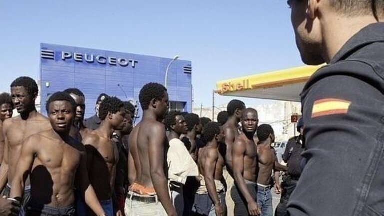 Un agente conduce a los inmigrantes al CETI.