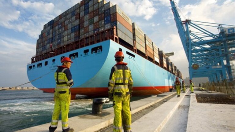 Estibadores esperan el atraque de un barco de carga.