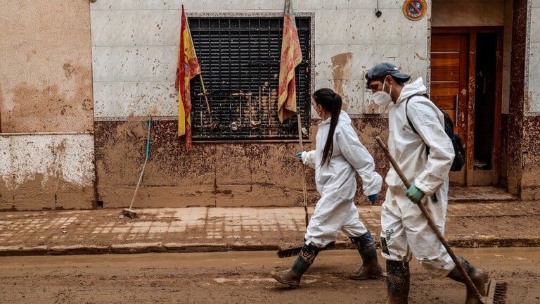 Varios voluntarios limpian calles en Masanasa. (Foto: Rober Solsona / Europa Press)