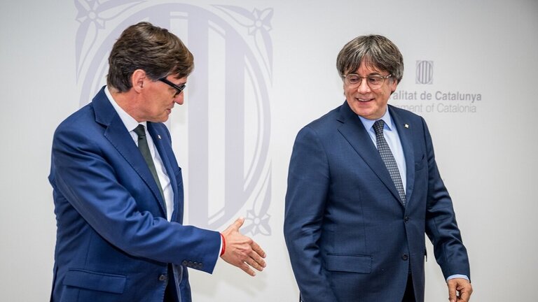 El presidente de la Generalitat, Salvador Illa (i), saluda al presidente de Junts per Catalunya, Carles Puigdemont (d), durante una reuni&oacute;n, a 2 de agosto de 2025, en Bruselas (Firma: Jasper Jacobs / Europa Press).