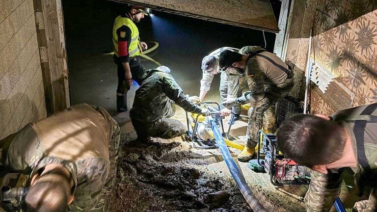Militares del Ej&eacute;rcito de Tierra y de la UME limpian un garaje en la zona afectada por la DANA con ayuda de una bomba de achique (Firma: @EjercitoTierra).