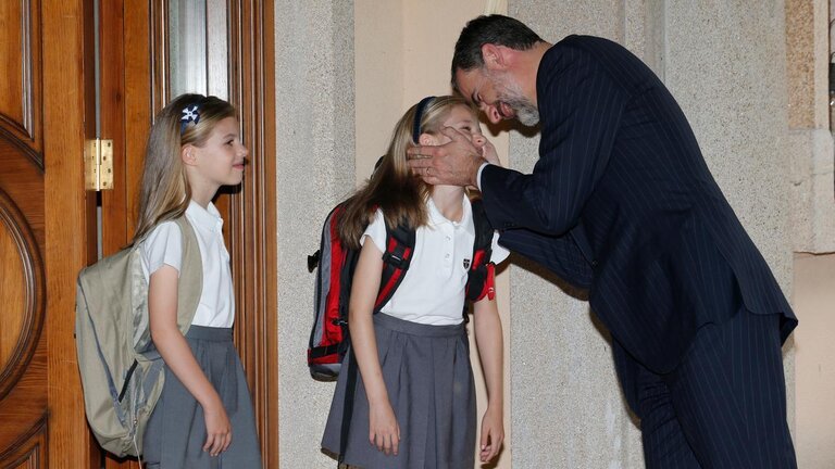 El rey Felipe da un beso a la princesa Leonor en presencia de la infanta Sof&iacute;a.