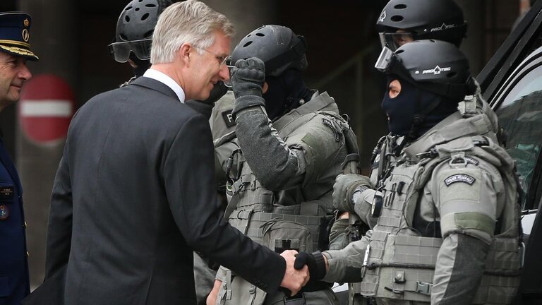 El rey Felipe de B&eacute;lgica saluda a un polic&iacute;a de la unidad antiterrorista.
