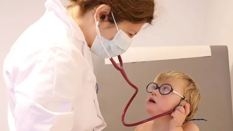 Una médico con un niño Síndrome de Down. 