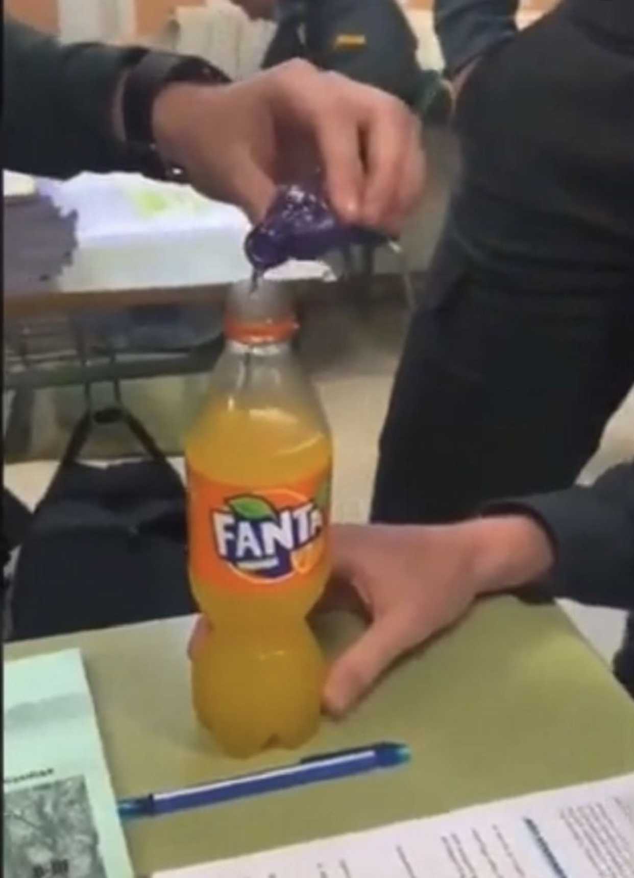 Momento en el que un alumno echa alcohol en un refresco.