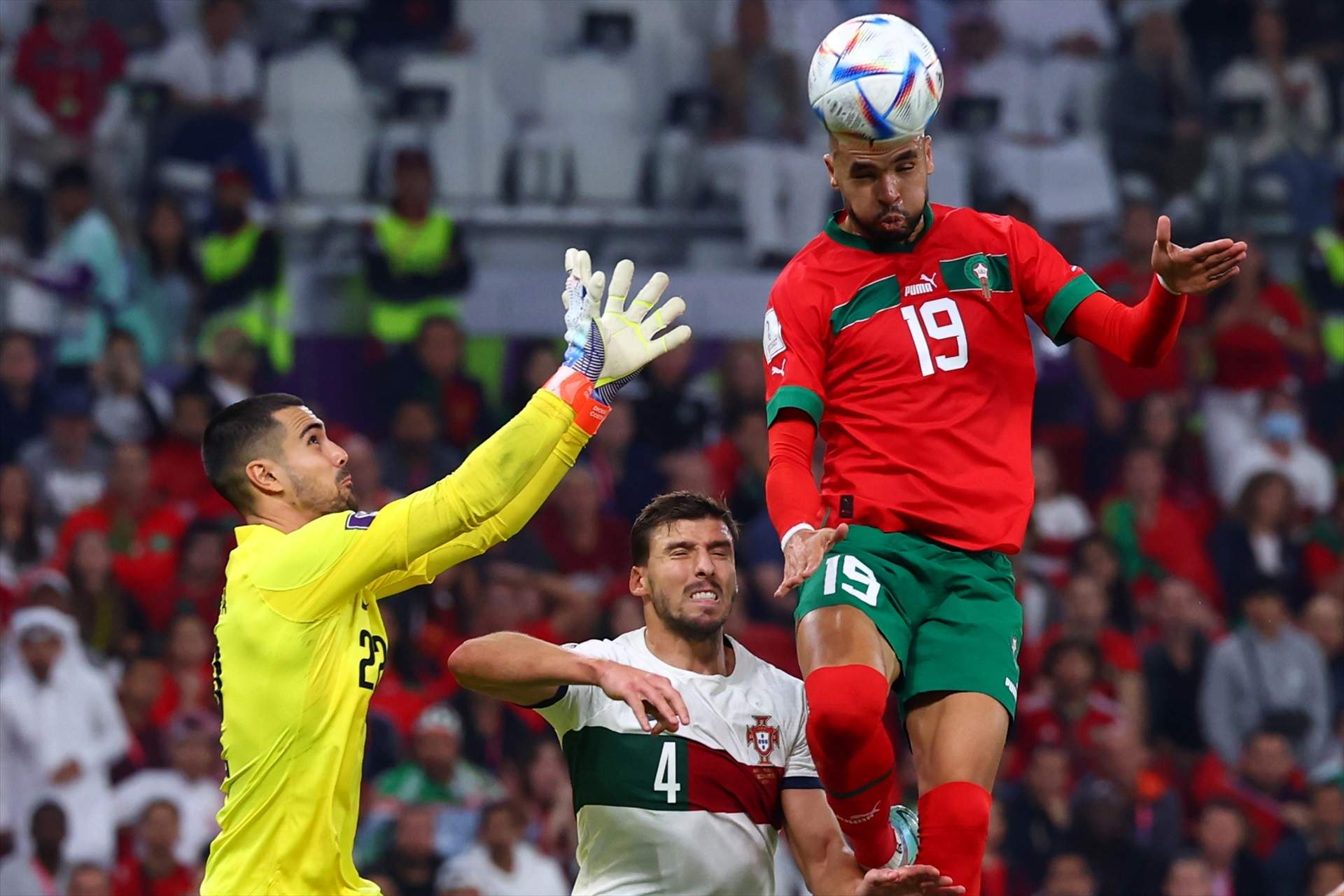 10 December 2022, Qatar, Doha: Morocco's Youssef En-Nesyri scores his side's first goal against Portugal's Ruben Dias and Diogo Costa during the FIFA World Cup Qatar 2022 Quarter-Final soccer match between Morocco and Portugal at Al-Thumama stadium. Photo: Tom Weller/dpa