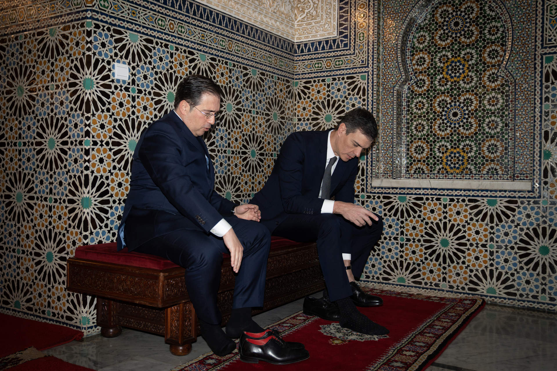 El ministro de Asuntos Exteriores, Unión Europea y Cooperación, José Manuel Albares (i), y el presidente del Gobierno, Pedro Sánchez 8d), se descalzan a su llegada al Mausoleo de Mohamed V, a 2 de febrero, en Rabat.