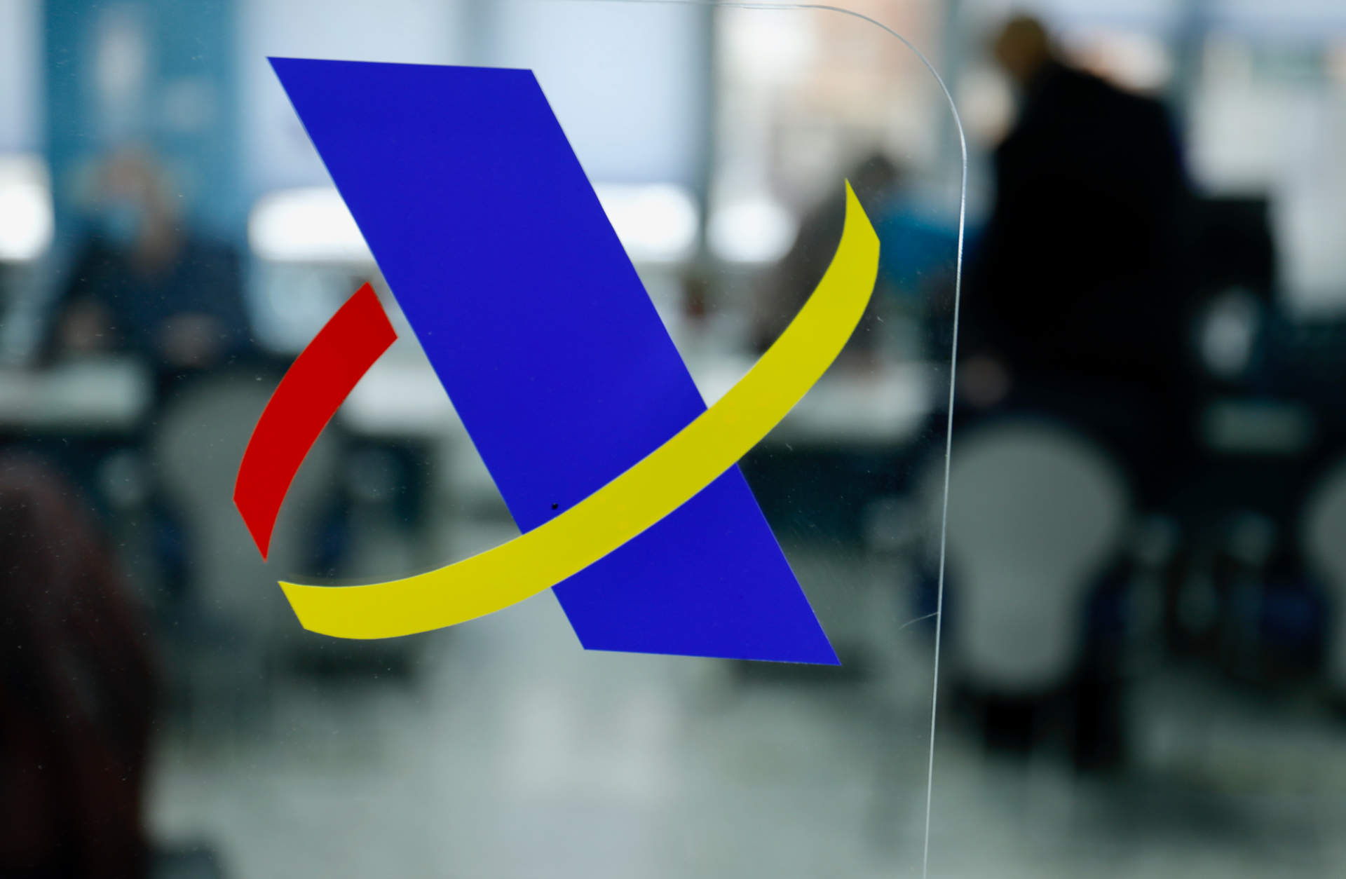 Logotipo de la Agencia Tributaria en una mampara en una oficina.