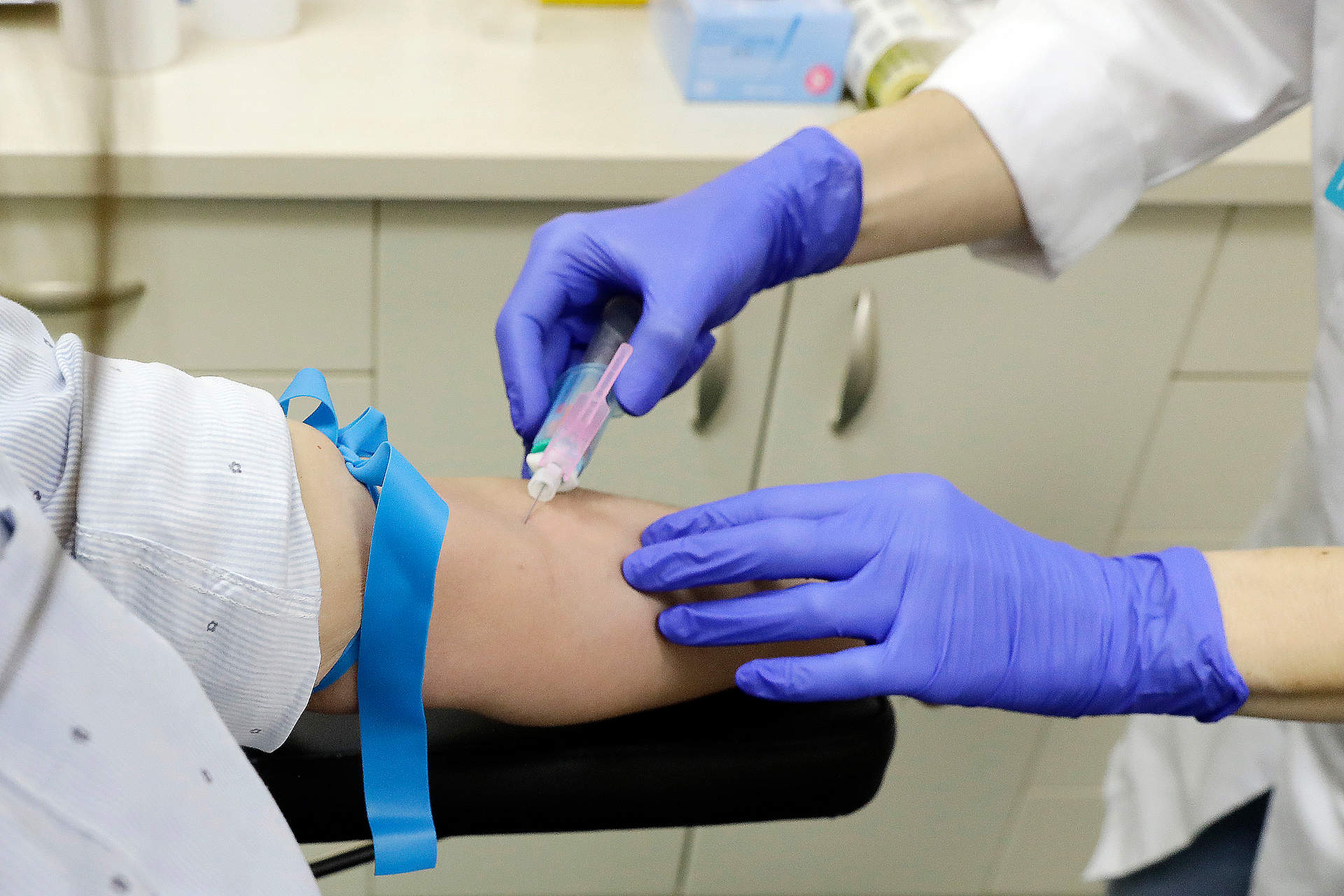 Un enfermero extrae sangre a una paciente.