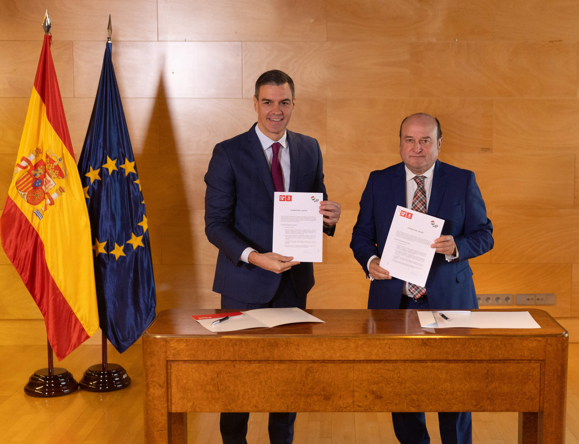 El presidente del Gobierno en funciones y candidato a la reelección, Pedro Sánchez (i), y el presidente del EBB del PNV, Andoni Ortuzar (d), firman un acuerdo para la investidura, en el Congreso de los Diputados.
