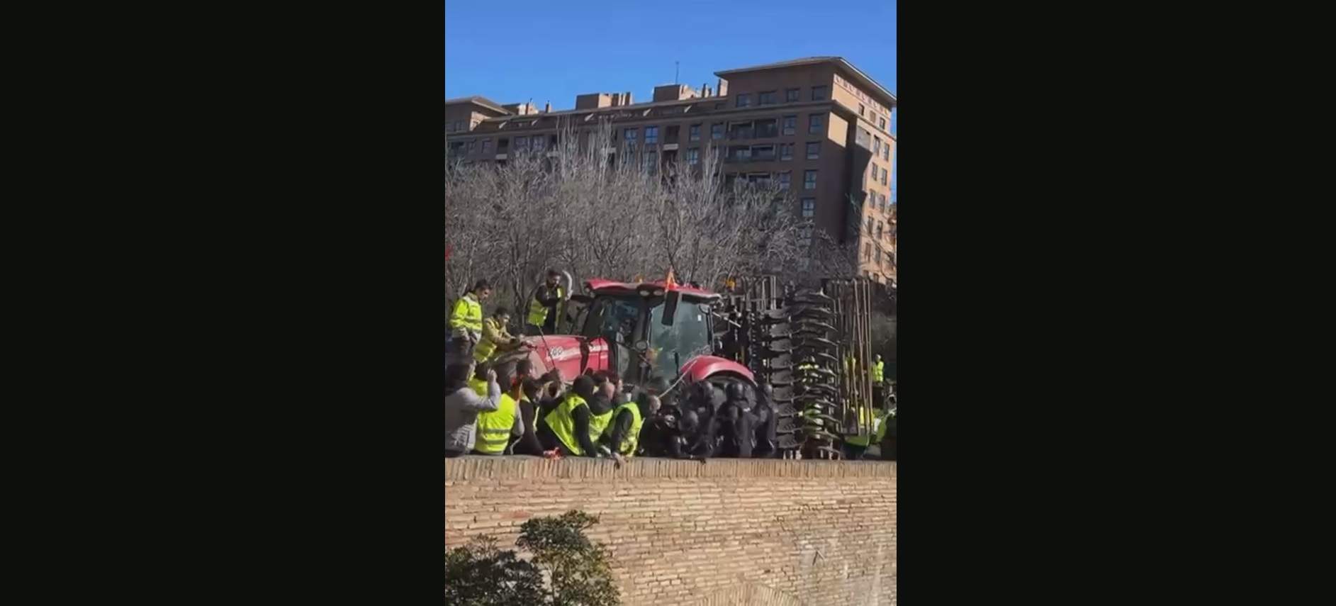 Agricultores animan a tirar de un puente a los antidisturbios que les impiden llegar a las Cortes de Aragón