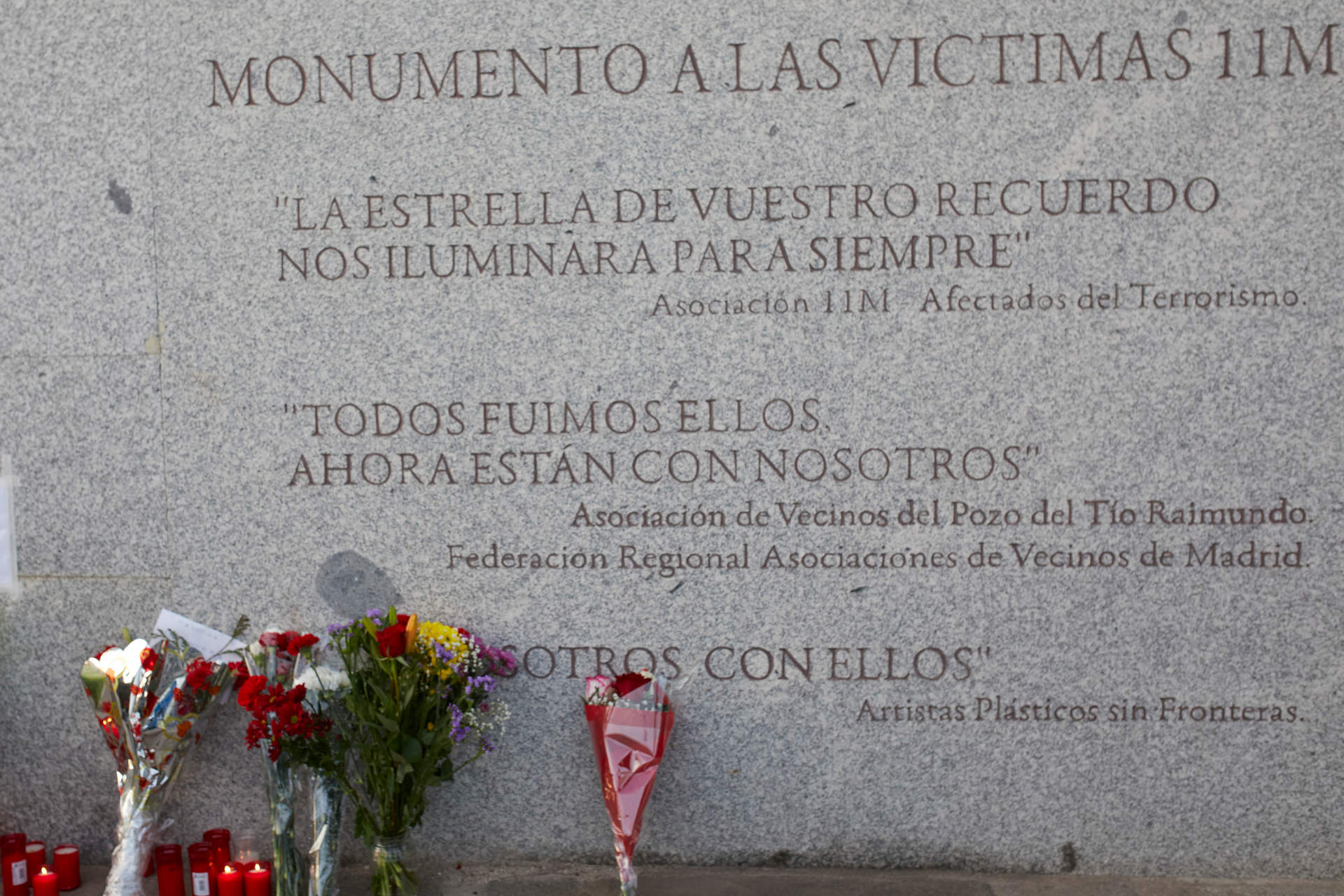 Ramos de flores en el monumento a las víctimas del 11-M en la estación de tren de El Pozo, uno de los lugares del atentado en Madrid.