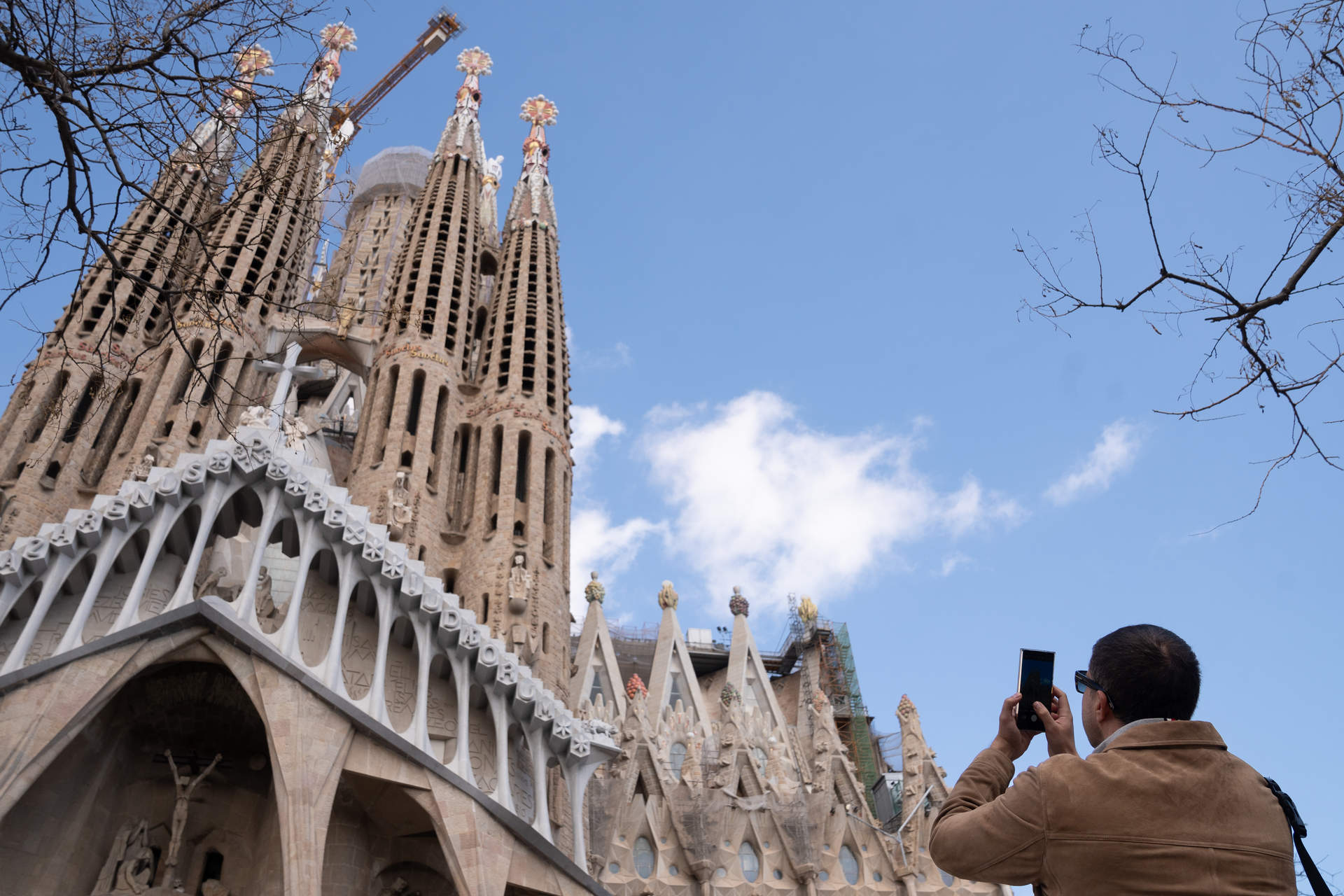 Un turista saca una foto junto a la Sagrada Familia, en Barcelona. Foto: David Zorrakino / Europa Press