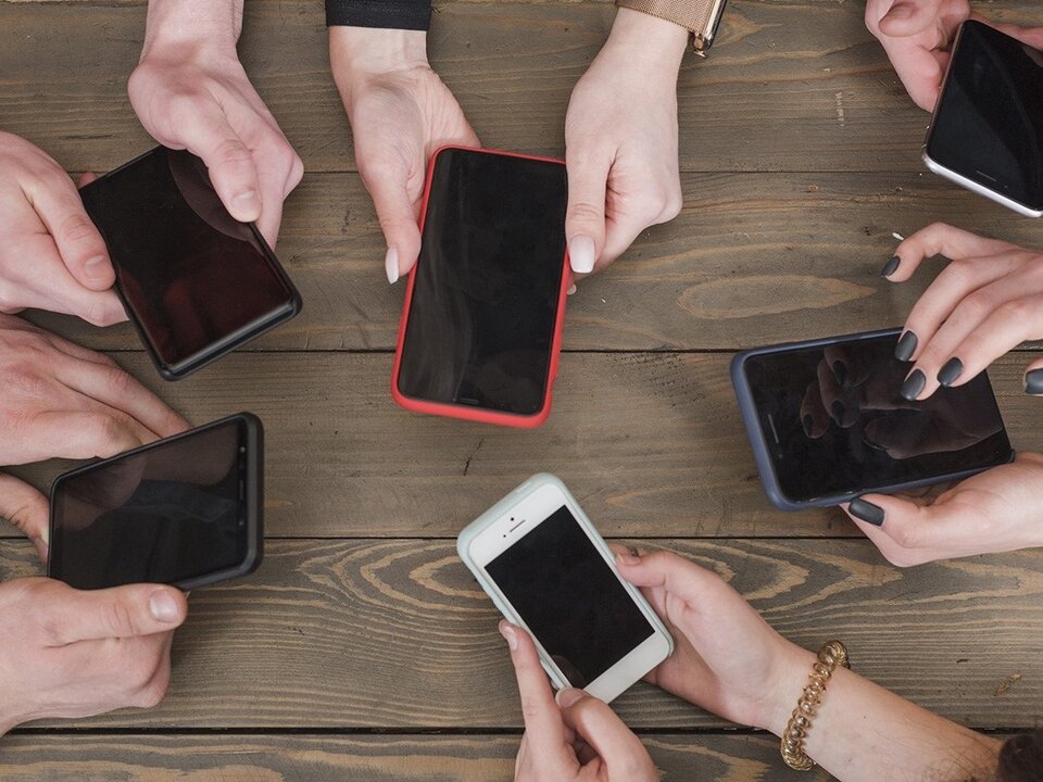 Jóvenes con sus teléfonos móviles encima de una mesa. (Foto: Europa Press)